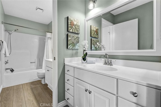 full bath featuring visible vents, shower / bath combo with shower curtain, vanity, wood finished floors, and toilet