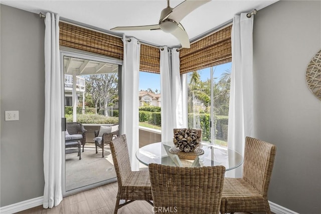 dining area with a healthy amount of sunlight, baseboards, a ceiling fan, and light wood-style flooring