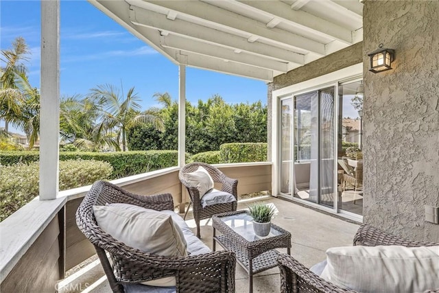 sunroom / solarium featuring beamed ceiling and an outdoor hangout area