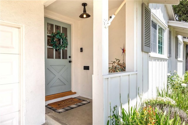 entrance to property with board and batten siding and stucco siding