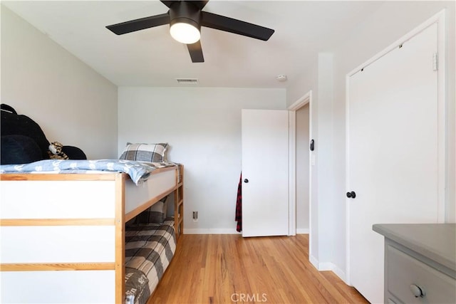 bedroom featuring a ceiling fan, baseboards, visible vents, and light wood-style flooring