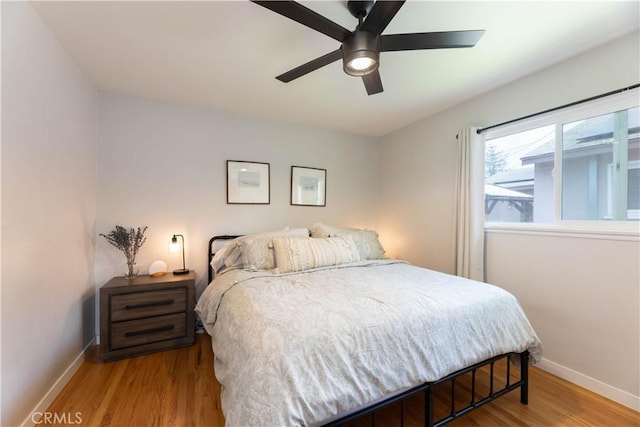 bedroom featuring baseboards, ceiling fan, and wood finished floors