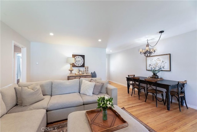 living area featuring light wood-type flooring, recessed lighting, baseboards, and a notable chandelier