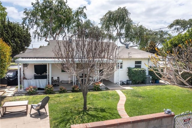 rear view of property featuring a patio area, stucco siding, and a yard