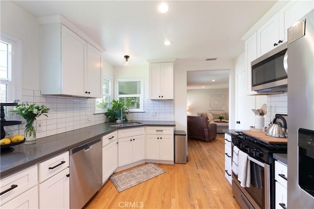 kitchen with stainless steel appliances, visible vents, a wealth of natural light, and a sink