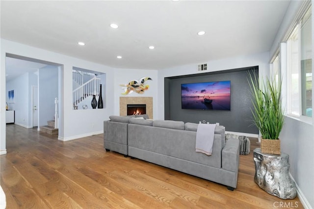 living area with visible vents, recessed lighting, stairs, and wood finished floors
