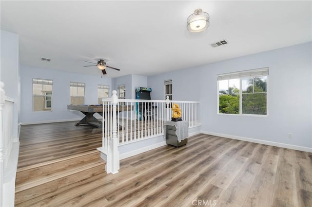 living room featuring baseboards, a ceiling fan, and wood finished floors