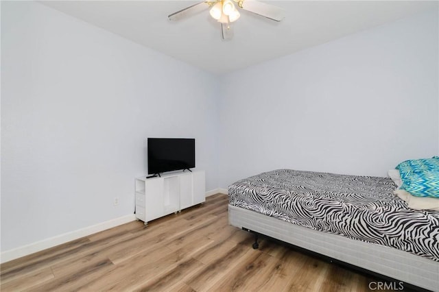 bedroom with baseboards, ceiling fan, and wood finished floors