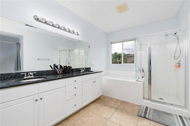 bathroom featuring a sink, tile patterned flooring, and a stall shower