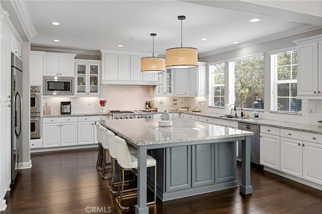 kitchen featuring crown molding, a sink, a breakfast bar area, and stainless steel appliances