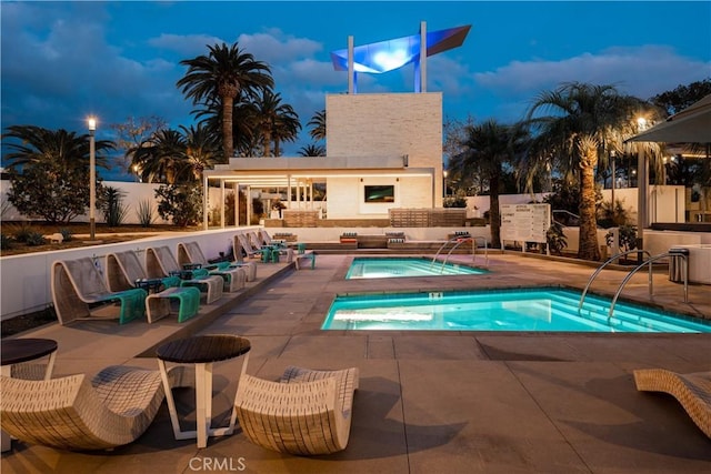 view of pool featuring outdoor lounge area, a community hot tub, and a patio area