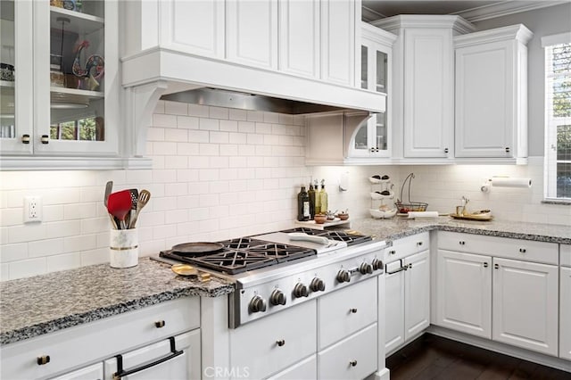 kitchen with white cabinetry, backsplash, light stone countertops, and stainless steel gas stovetop