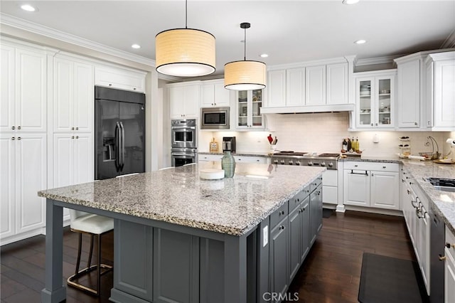 kitchen featuring ornamental molding, a kitchen island, gray cabinets, white cabinetry, and appliances with stainless steel finishes
