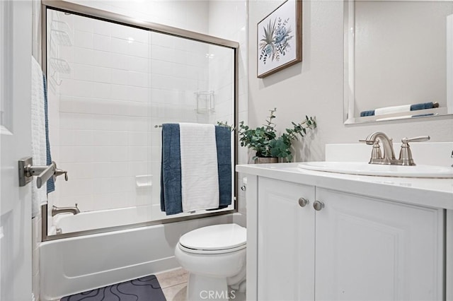 full bathroom featuring vanity, tile patterned flooring, combined bath / shower with glass door, and toilet