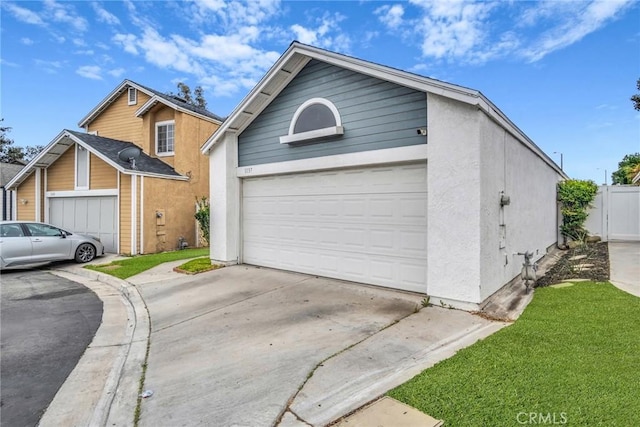 view of front facade with a garage, stucco siding, and concrete driveway