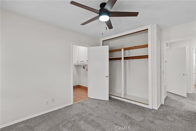 unfurnished bedroom with a closet, baseboards, ceiling fan, a textured ceiling, and carpet