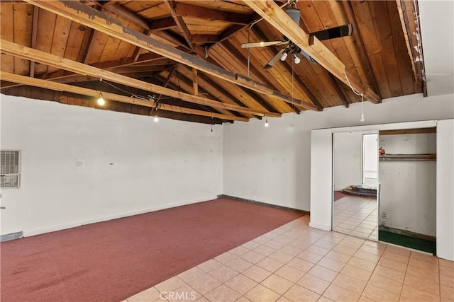 interior space with light colored carpet, a ceiling fan, wood ceiling, and light tile patterned floors