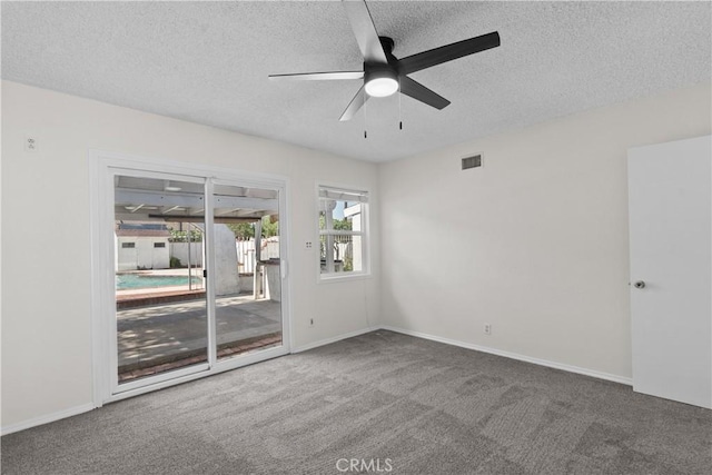 carpeted empty room featuring a ceiling fan, a textured ceiling, visible vents, and baseboards