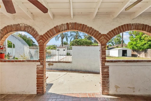 view of gate with an outbuilding, fence private yard, and a storage unit