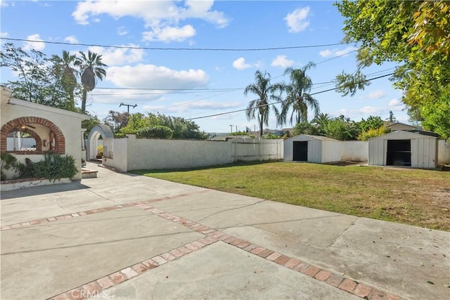 view of yard featuring an outdoor structure, fence private yard, and a shed