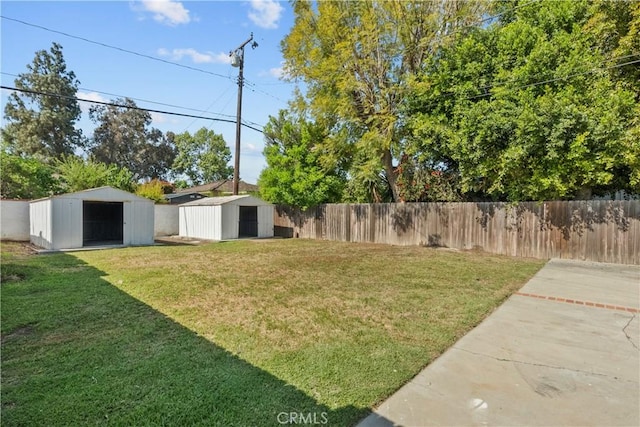 view of yard with a fenced backyard, a storage unit, and an outdoor structure