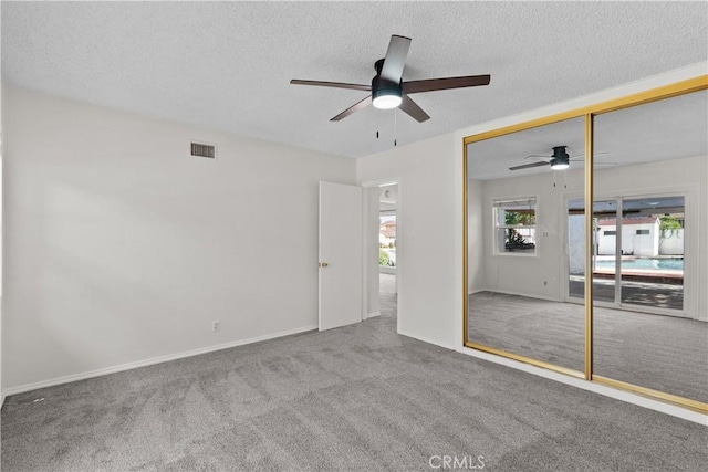 unfurnished bedroom with carpet floors, a ceiling fan, and a textured ceiling