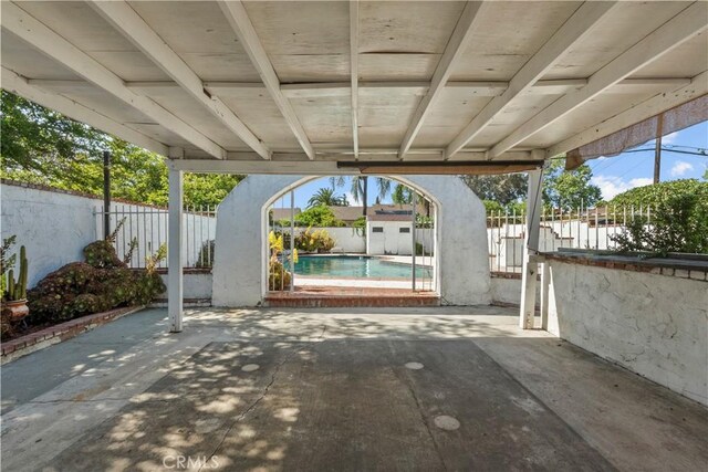 view of patio with a fenced backyard, an outbuilding, a carport, and a shed