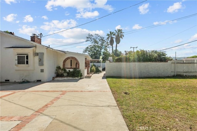 view of yard featuring fence and concrete driveway
