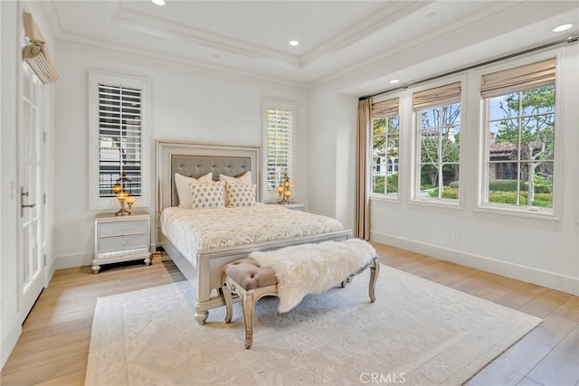 bedroom with crown molding, baseboards, recessed lighting, a raised ceiling, and light wood-style flooring