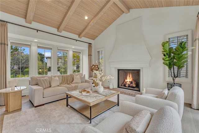living area featuring wood ceiling, a fireplace, light wood-type flooring, and high vaulted ceiling