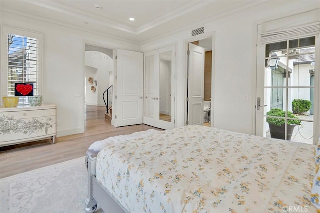 bedroom featuring access to outside, arched walkways, wood finished floors, visible vents, and ornamental molding