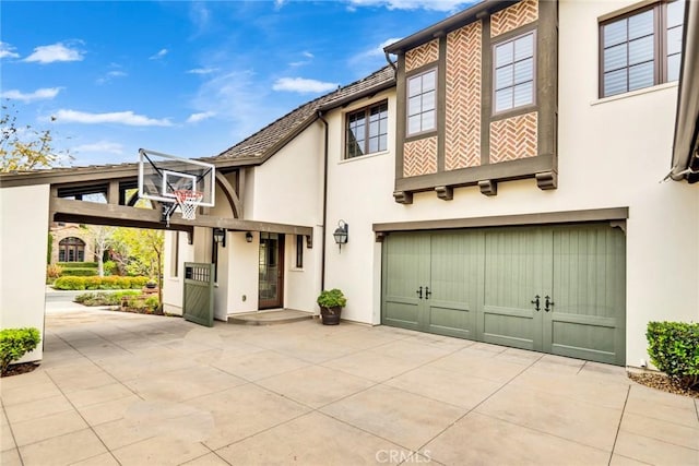 view of front facade with concrete driveway, an attached garage, and stucco siding