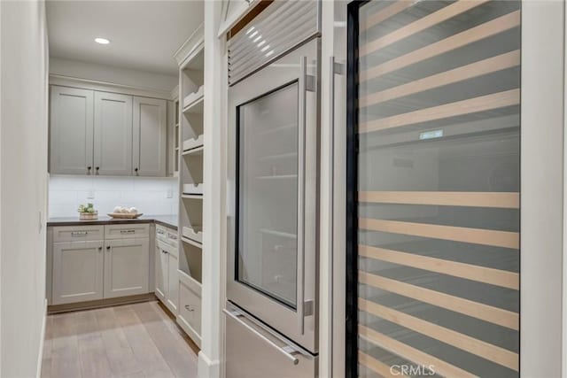 kitchen with open shelves, dark countertops, recessed lighting, decorative backsplash, and light wood-type flooring