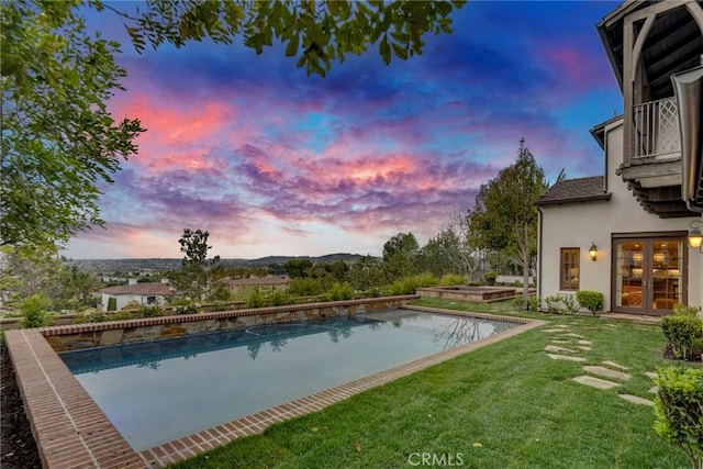 pool with french doors and a yard