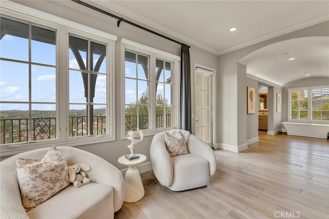 living area featuring recessed lighting, baseboards, light wood-type flooring, and arched walkways