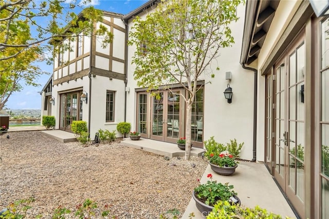 rear view of property featuring a patio area, stucco siding, and french doors