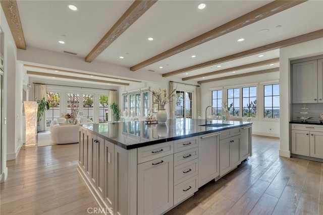 kitchen featuring a sink, dark countertops, french doors, and beam ceiling