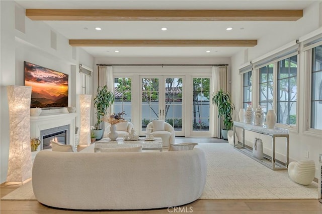 living room featuring plenty of natural light, beam ceiling, and wood finished floors