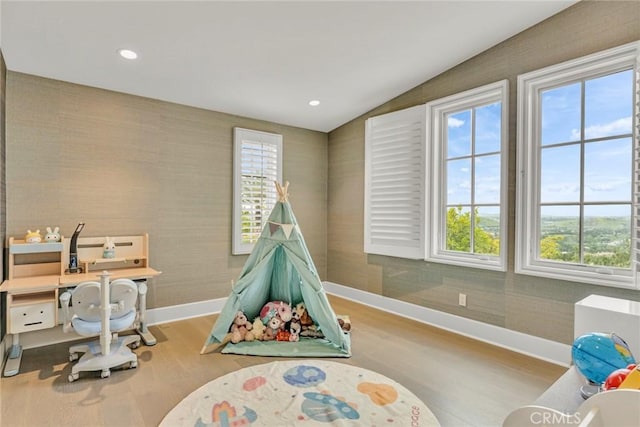 rec room featuring baseboards, wallpapered walls, wood finished floors, and lofted ceiling