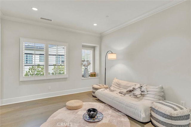 living room with crown molding, recessed lighting, baseboards, wood finished floors, and visible vents