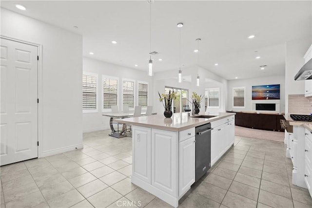 kitchen with light countertops, dishwasher, light tile patterned flooring, and open floor plan