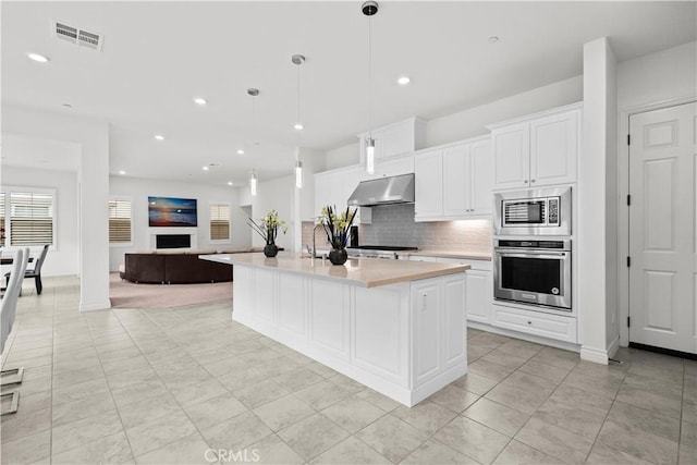 107 Frontier, Irvine, CA 92620 - kitchen featuring stainless steel appliances, under cabinet range hood, open floor plan, light countertops, and backsplash