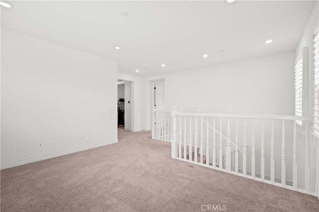 carpeted spare room featuring recessed lighting and baseboards