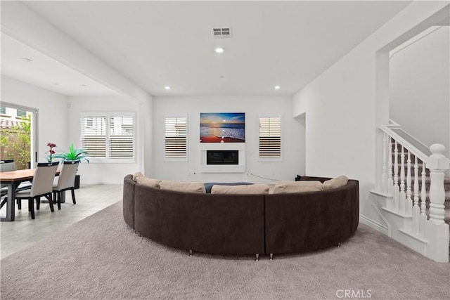 living area featuring stairs, recessed lighting, and visible vents