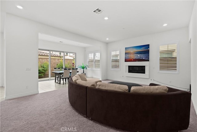 living area featuring a glass covered fireplace, carpet flooring, recessed lighting, and visible vents