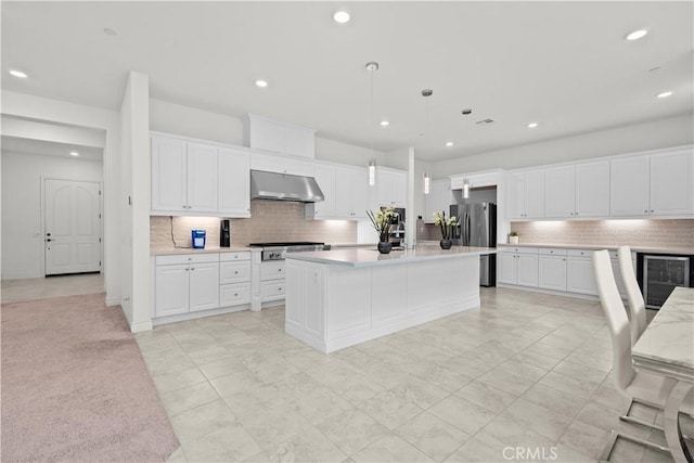 kitchen featuring recessed lighting, white cabinetry, under cabinet range hood, tasteful backsplash, and appliances with stainless steel finishes