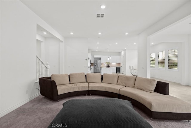 living area with light carpet, stairs, recessed lighting, baseboards, and visible vents