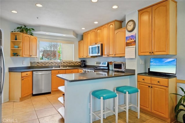 kitchen featuring open shelves, appliances with stainless steel finishes, dark countertops, and a sink