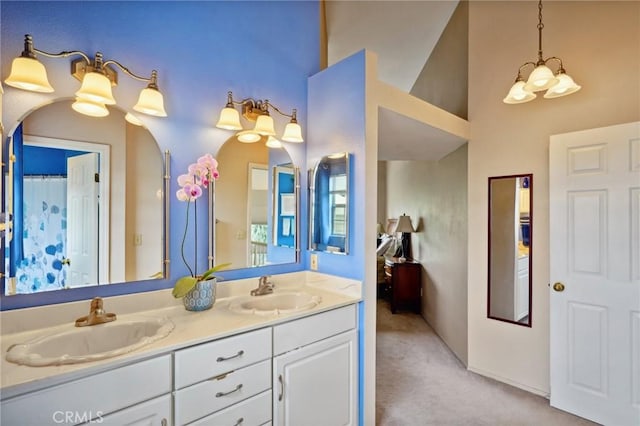 bathroom featuring double vanity, a sink, and a towering ceiling