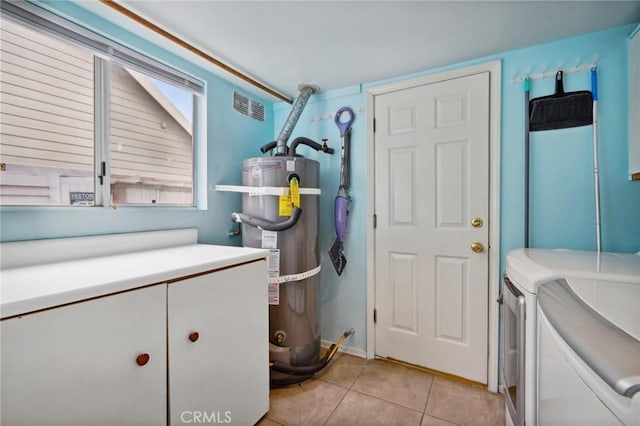 washroom with light tile patterned flooring, laundry area, separate washer and dryer, secured water heater, and visible vents